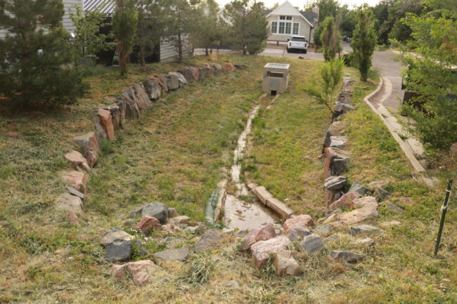 Sunken bioretention area with a visible inlet and outlet.
