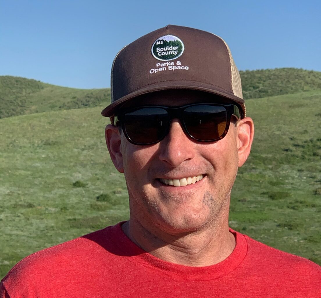 Headshot of a man in sunglasses and a Boulder County Parks and Open Space ball cap.